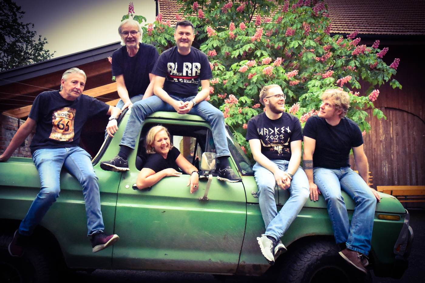 Die sechs Musiker von Route 66 auf einem gr&uuml;nen Ford Bronco